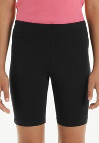 Shorts de vélo noirs en mélange de coton avec une taille extensible, une coupe ajustée et une texture lisse, se terminant juste au-dessus du genou.