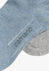 Calzino in cotone azzurro chiaro con una finitura testurizzata, caratterizzato da un accento grigio sul polsino e la scritta "camano" stampata in grigio sul lato.