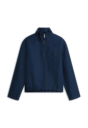 Marineblå lynlåsjakke med høj krave, elastisk kant og diskret broderet logo på brystet. Glat stof og struktureret design.