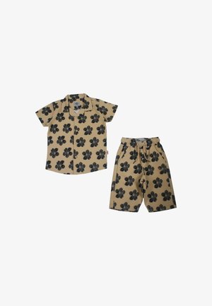 Ensemble chemise manches courtes beige et short assorti avec motif floral noir, taille élastique et poches avant sur le short.