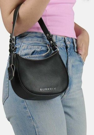 Sort læderhåndtaske med struktureret finish, buet form, justerbar rem og sølv "BURKELY" logo på fronten. Sammen med blå jeans.