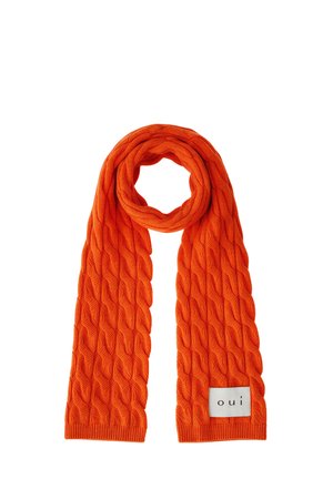Écharpe orange en maille torsadée pliée en boucle avec une étiquette blanche indiquant "oui" au bord inférieur.