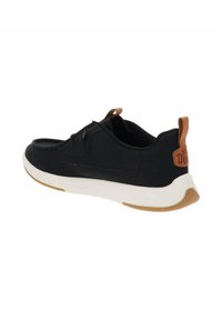 Sneaker nera con tomaia in tessuto liscio, punta rotonda e intersuola bianca. Presenta un dettaglio in pelle marrone sul tallone e sui lacci.