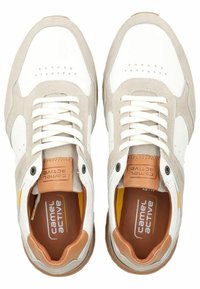 Weiße und beige Sportschuhe aus Wildleder und Leder, mit runder Zehenpartie, Schnürdesign und braunen Akzenten an Ferse und Zunge.