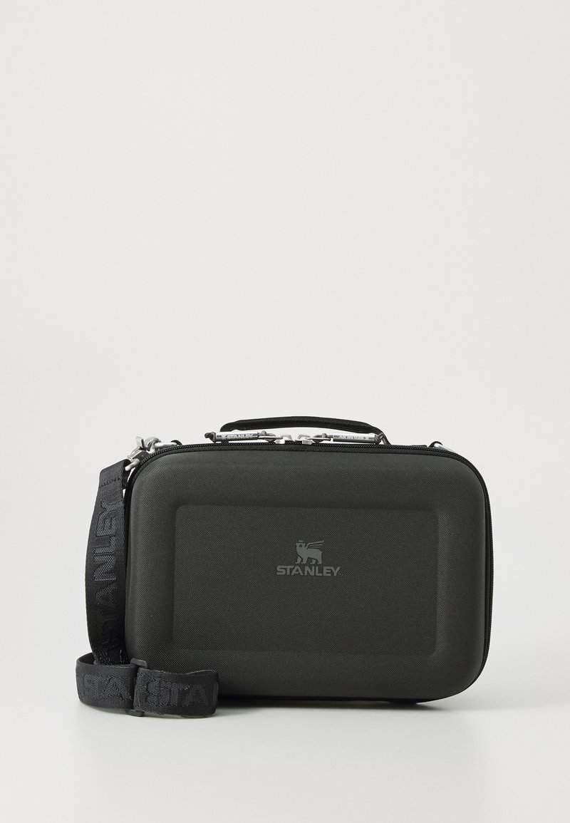 Black hard case with a textured exterior, a top handle, and a detachable strap. Features a silver zipper and an embossed logo on the front.