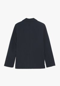 Granatowa marynarka z wyciętym kołnierzem, pojedynczym rozcięciem z tyłu i rękawami na cztery guziki. Miękka tkanina o textured, o dopasowanym kroju.