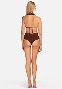 Brązowy bikini z halterem i zapięciem na plecach. Wysokie majtki o gładkiej fakturze i minimalnym pokryciu.