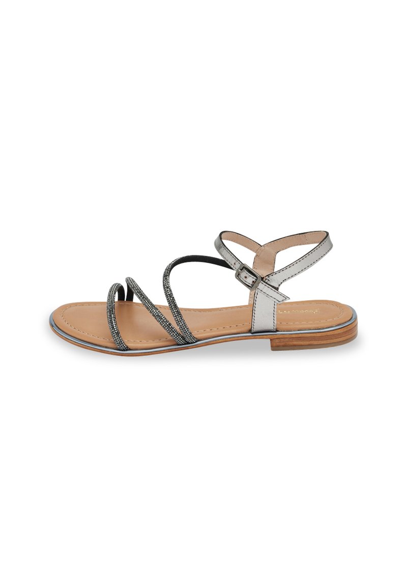 Sandalo con cinturini in argento e nero, dotato di una soletta in pelle liscia e un tacco in legno basso. Presenta una chiusura con fibbia e sottili dettagli metallici.