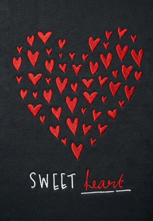 Cœurs rouges brodés disposés en grande forme de cœur au-dessus des mots cousus "SWEET heart" sur un tissu sombre.