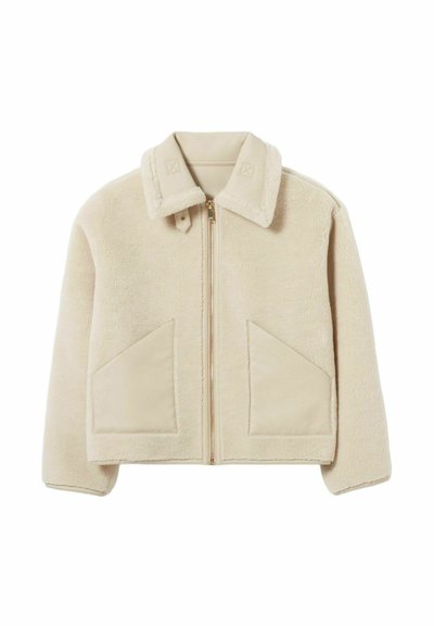 Giacca in pelliccia sintetica beige con chiusura a zip, colletto, due ampie tasche frontali e delicati dettagli di cucitura sul colletto e sulle tasche.