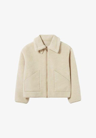 Giacca in pelliccia sintetica beige con chiusura a zip, colletto, due ampie tasche frontali e delicati dettagli di cucitura sul colletto e sulle tasche.