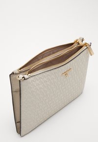 Pochette in pelle sintetica beige con due scomparti zip dorati, caratterizzata da un motivo testurizzato e un sottile dettaglio del logo.