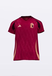 Maillot à manches courtes bordeaux avec motif en losanges texturés, accents dorés et détails noirs aux épaules. Présente un blason sur le côté gauche de la poitrine.