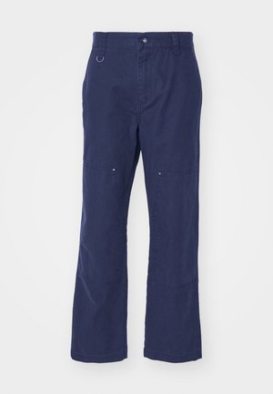 Pantaloni in cotone blu navy con design a gamba dritta, dotati di tasche laterali, chiusura a pulsante e un accento in metallo a forma di anello sulla vita.