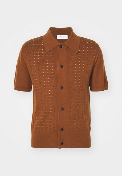 Polo de malha castanho de mangas curtas com um design texturizado, fecho de botão e colarinho pontudo. Apresenta linhas verticais com detalhes subtis.