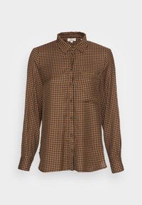 Camicia a maniche lunghe a scacchi marrone e beige con colletto, bottoni frontali e una tasca sul petto. Realizzata in tessuto leggero.