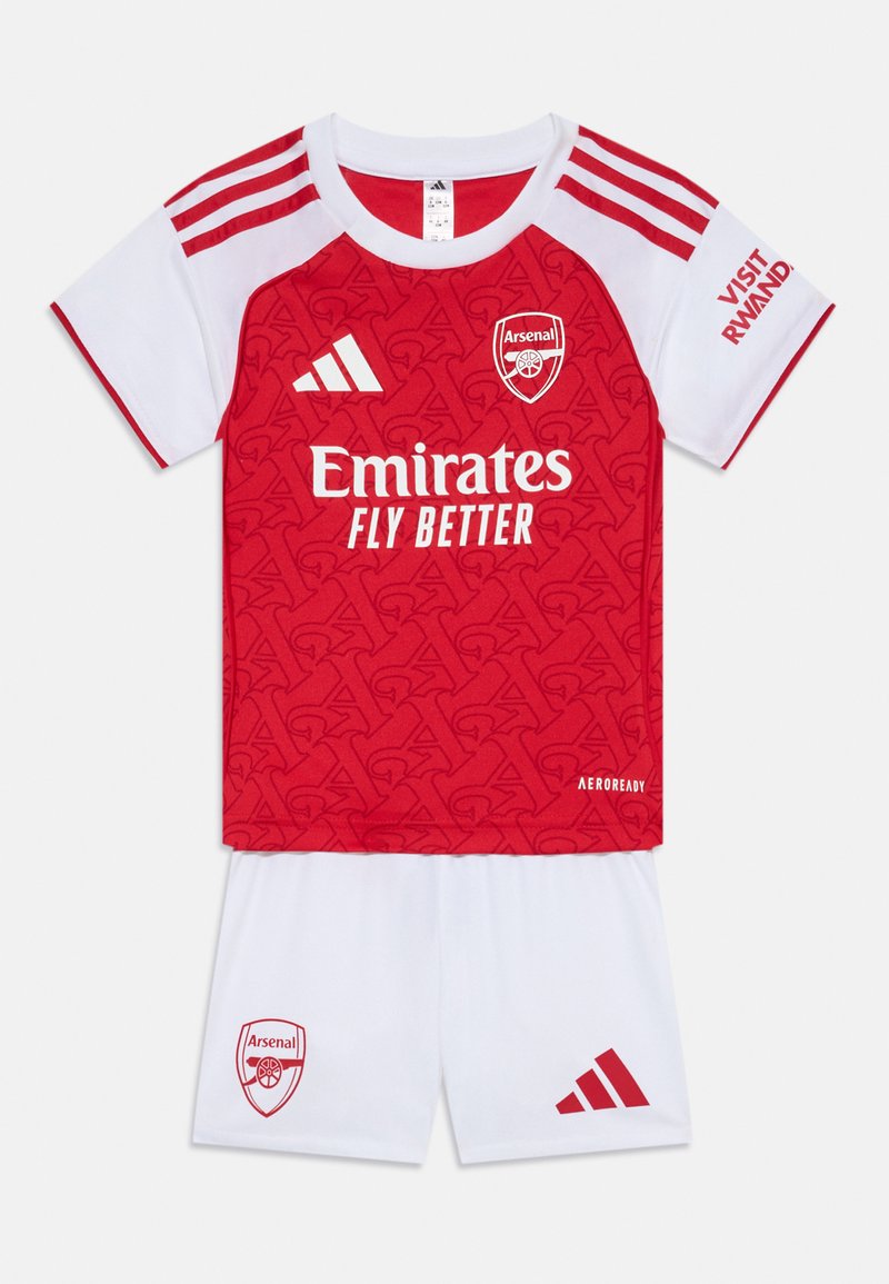 Röd och vit ungdomsfotbollskit; tröjan har en strukturerad röd design med Arsenal-logotyp, vita shorts och tre-rands axeldetaljer.