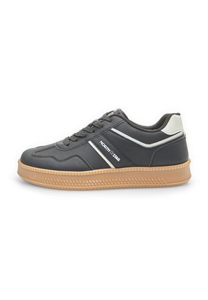 Black athletic sneaker with a textured rubber sole, contrasting white stripes, and a padded collar. Features a lace-up design with a rounded toe.