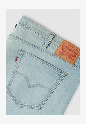 Lichtblauwe achterzak van Levi's spijkerbroek met kenmerkende rode tab en bruine leren merklabel waarop model 502 en stikdetails te zien zijn.