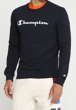 Mørkeblå langærmet sweatshirt lavet af bomuldsblanding, med hvid "Champion" logo på brystet samt ribbede manchetter og kant.