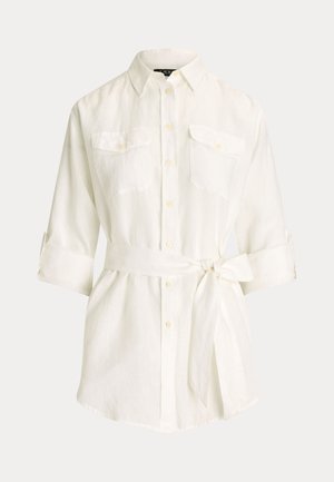 Valge linane särk nööbitava kraega, kahe ees taskuga, ülesrullitavaid varrukaid ja ise siduvat vöökohta. Sile ja kerge tekstuur.