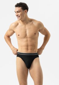 Schwarze gerippte Slips mit einem elastischen Bund in grauen Streifen, die ein hochgeschnittenes Bein-Design für eine körperbetonte Passform aufweisen. Glatte Textur.