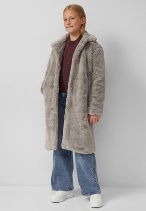 Manteau en fausse fourrure grise avec capuche et fermeture à boutons, manches longues et coupe décontractée. Porté sur un pull bordeaux et un jean évasé.