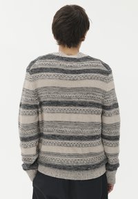 Stickad tröja med horisontella ränder i ljusbeige och mörkgrå nyanser. Texturerat tyg med ribbat nederkant och ärmavslut, rund halsringning.