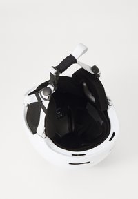 Hvit hjelm med en glatt overflate, svart polstret innside, justerbare stropper og ventilasjonshull for luftstrøm.