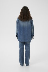 Denim jacket and jeans in a medium blue shade, with a relaxed fit, visible stitching, and a slight fade on the back of the jacket.