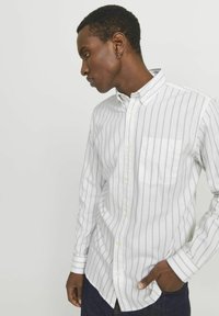 Wit gestreept overhem shirt met een borstzak, voorzien van verticale grijze strepen en lange mouwen, gemaakt van lichtgewicht stof.