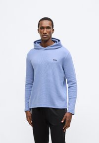 Sweatshirt azul claro com capuz, tecido texturizado, com o logótipo "BOSS" preto no peito e mangas compridas.