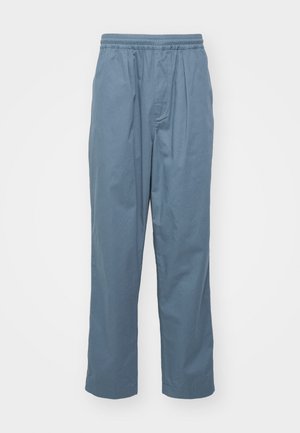 Pantaloni de culoare bleu deschis, realizați din bumbac, cu un brâu elastic, pliuri în față și o siluetă relaxată. Textură netedă.
