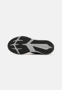 Semelle extérieure en caoutchouc noir avec un motif en vagues et des détails de semelle intermédiaire blanche. Présente un logo surélevé et des éléments de traction pointus pour une meilleure adhérence.