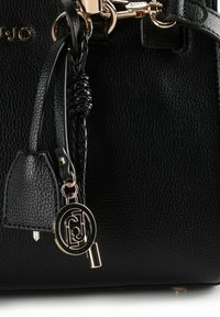 Zwarte leren handtas met een gestructureerde afwerking, voorzien van gouden beslag, gevlochten accenten en een logo hanger aan het riempje.