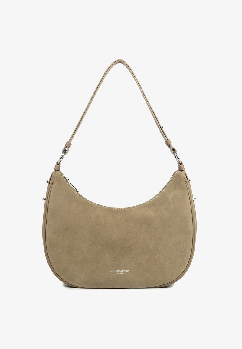 Beige suede shoulder bag with a curved shape, featuring a simple silver-tone zipper, a single strap, and embossed branding on the front.