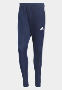 Marina atletiska byxor med vita ränder på sidorna och en Adidas-logotyp på övre vänstra benet, designade för komfort och prestanda.