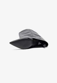 Must must jämeda varbaga must nahast stiletto saapad, millel on sile tekstuur. Omab voolavat disaini ja kõrget, läikivat kontsa.