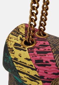 Wielokolorowa torebka z teksturowym wykończeniem, z złotym łańcuchem jako paskiem oraz dekoracyjnymi oczkami. Wzory obejmują czerń, zieleń, róż i żółć.