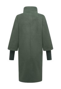 Manteau mi-long vert foncé en tissu doux avec un col montant, des manches larges et des poignets côtelés. Texture lisse sans motifs visibles.