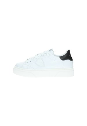 Sneaker bianco in pelle con finitura testurizzata, suola piatta bianca e accento nero sul tallone. Caratterizza una chiusura tradizionale con lacci e cuciture laterali.