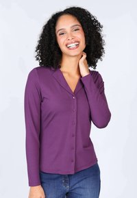 Purple long-sleeve button-up shirt with a collar, made from a soft fabric, featuring a subtle sheen and matching buttons down the front.