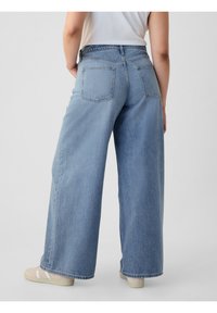 Vaaleansiniset leveälahkeiset farkut, joissa on korkea vyötärö. Niissä on kaksi takataskua ja raaka helma. Kangas on denim, jonka pinnassa on hieman tekstuuri.