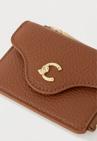 Portefeuille en cuir brun texturé avec ferrures dorées, doté d'un rabat festonné et d'un détail en forme de boucle, design compact pour un transport facile.