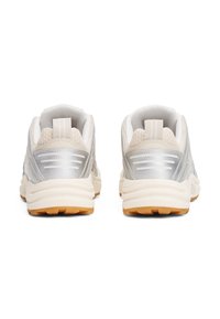 Sneakers with a metallic silver and beige mesh upper, padded collar, and rubber outsole. Features a pull tab and textured detailing.