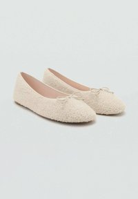 Ballerines en tissu couleur crème avec une texture pelucheuse, bout pointu et un petit nœud en accent à l'avant, semelle plate.