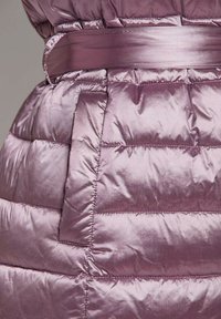 Gevoerde jas in iriserend mauve met een gladde textuur, voorzien van een ceinture taille en een zichtbare patch pocket voor extra detail.