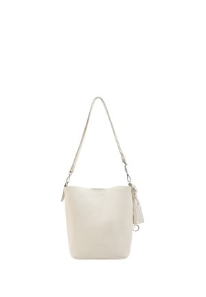 Cream-colored leather bucket bag with adjustable shoulder strap and small attached tag hanging on a white background.