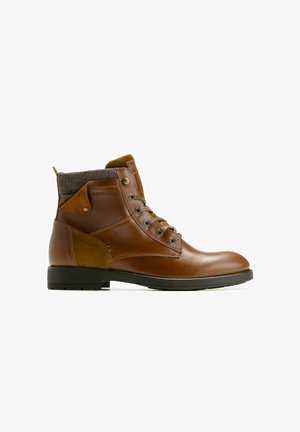 Bottines en cuir marron avec un col en tissu gris foncé texturé, un talon renforcé, six œillets et une semelle en caoutchouc plate.