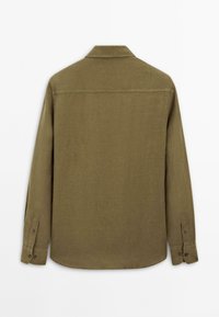 Olive green collared long-sleeve shirt, made of textured fabric, with buttoned cuffs and a curved hemline. Appears to be a casual design.